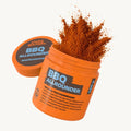 Oranger Behälter mit Text "BBQ ALLROUNDER", Gewürzpulver spritzt heraus.
