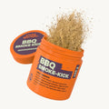 Orangene Dose mit Aufschrift 'BBQ SMOKE-KICK', braunes Pulver flockt.