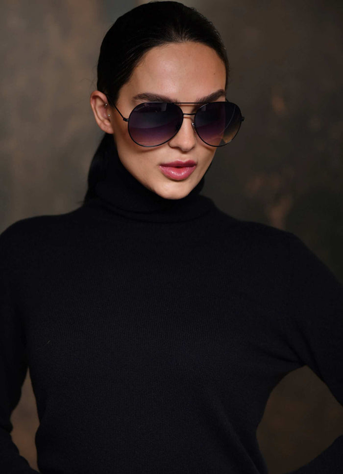 Women wearing black turtle neck cashmere in color black and matching black aviator sunglasses