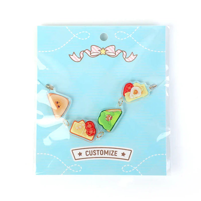 Custom acrylic charm bracelet with toast and breakfast food designs on blue card packaging
