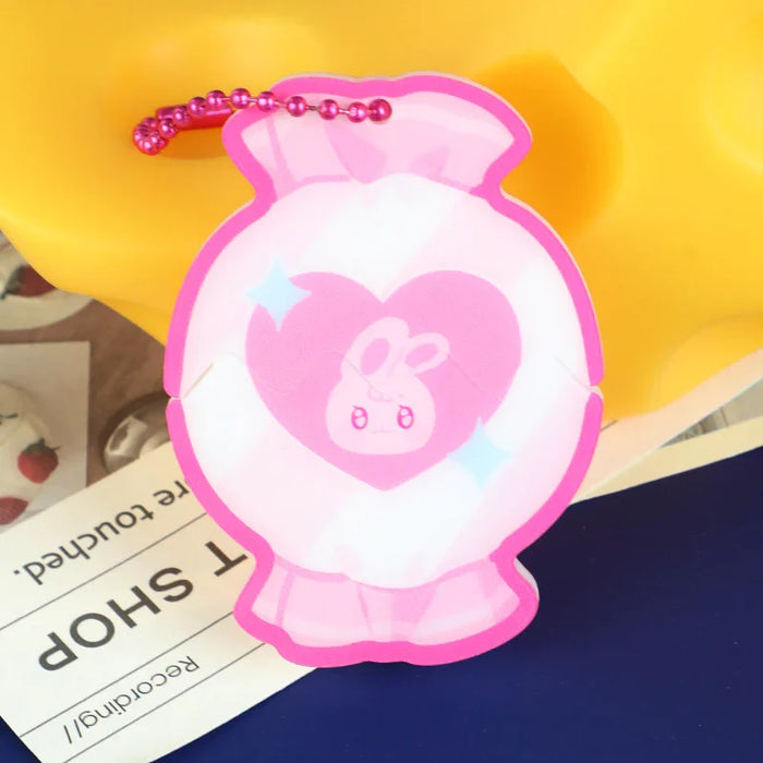 Pink acrylic candy-shaped keychain charm with cute bunny design and magnetic slide-out feature