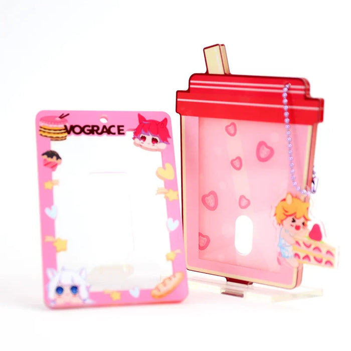 Custom acrylic photocard holders with pink cartoon designs and heart motifs, one with stand and keychain charm.