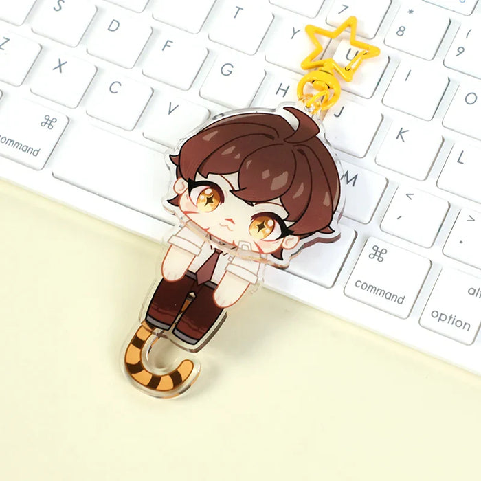 Custom acrylic keychain with cute anime character and yellow star clip on white keyboard