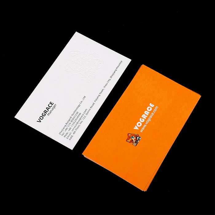 Custom business cards with white and orange designs, company logo and contact details visible