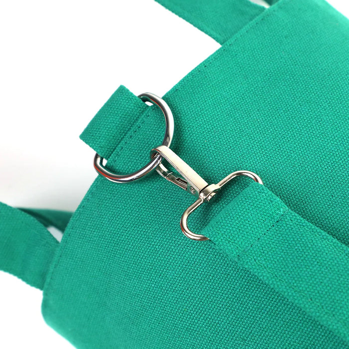Close-up of green canvas bucket bag with metal clasp and strap detail