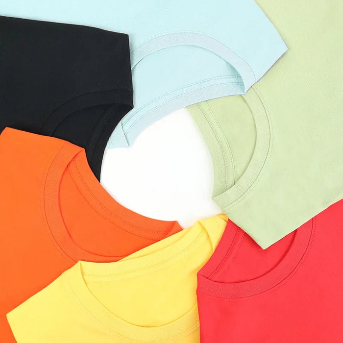 Assorted cotton children's crew neck t-shirts in black, light blue, green, orange, yellow, and red.
