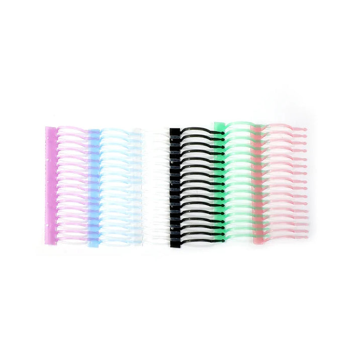 Assorted colored plastic notebook binding rings lined up on a white background
