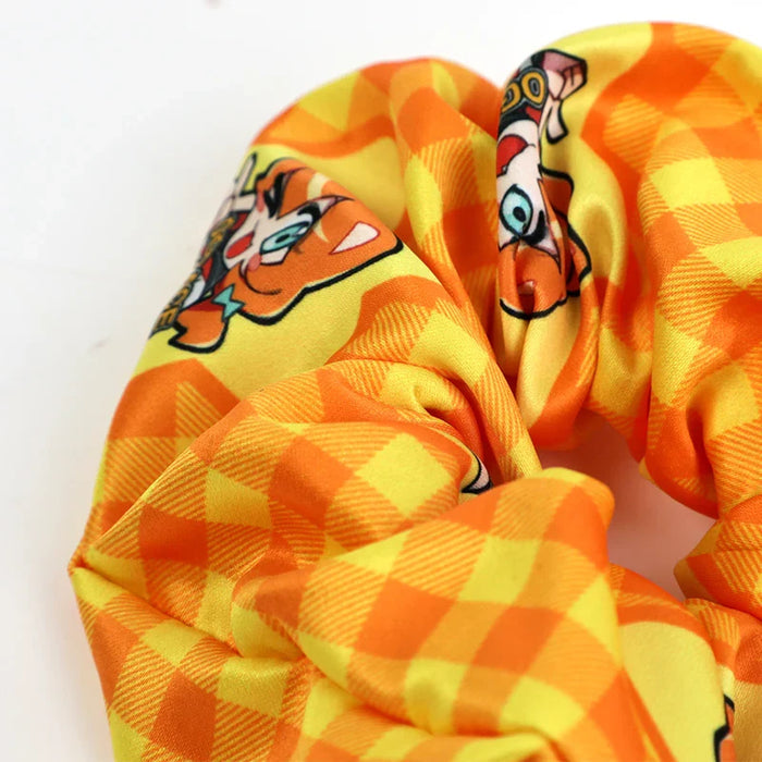 Custom anime scrunchie with orange checkered pattern and cartoon character print