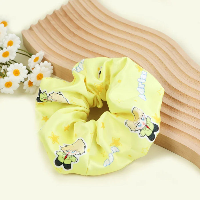 Custom yellow hair tie with cartoon character print and stars, displayed by daisies