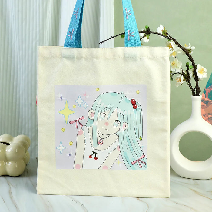 Custom canvas tote bag with blue handles and cute anime girl illustration, decorative background