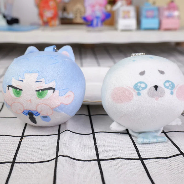 Two round custom manjuu plush toys with anime-style faces on a checkered table.