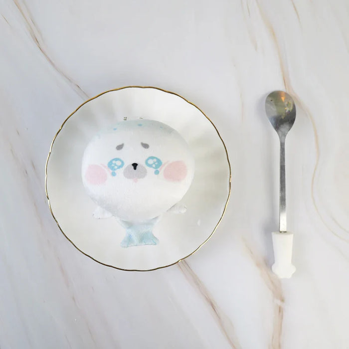 Round custom anime plush keychain shaped like a seal on a plate with a spoon beside it