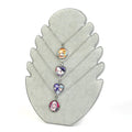 Anime character pendants on silver chains displayed on gray stand, featuring heart and round charms