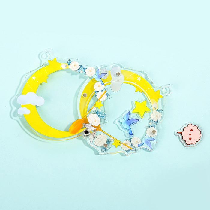 Custom openable acrylic shaker keychain with yellow moons, stars, flowers, and a blue hummingbird.