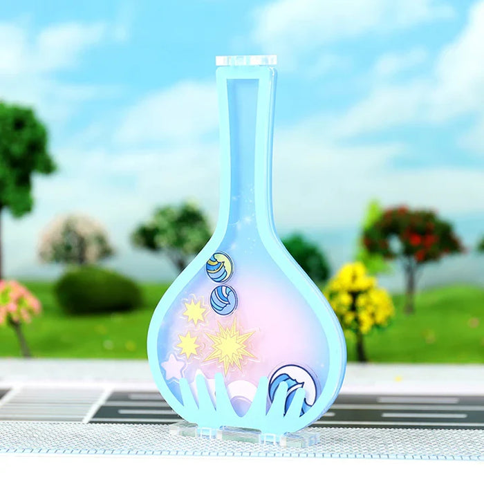 Custom acrylic shaker standee shaped like a flask with planets and stars, outdoor background