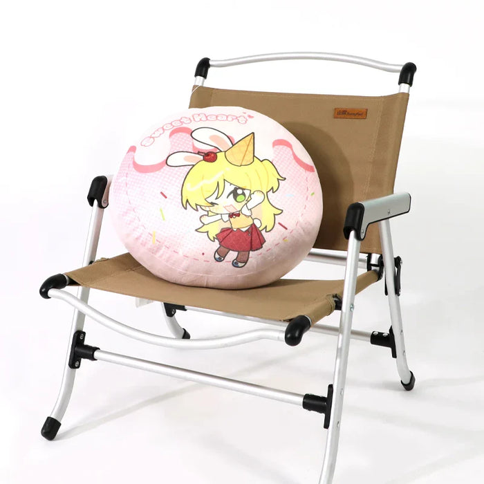 Round anime plush pillow with cartoon character on a folding chair, cute pastel design