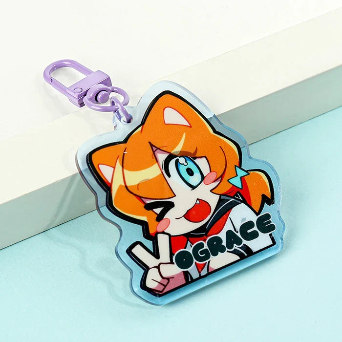 Colorful custom acrylic keychain with anime cat character and purple clasp on a blue background