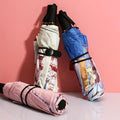 Custom printed anime umbrellas with colorful designs on a pink background