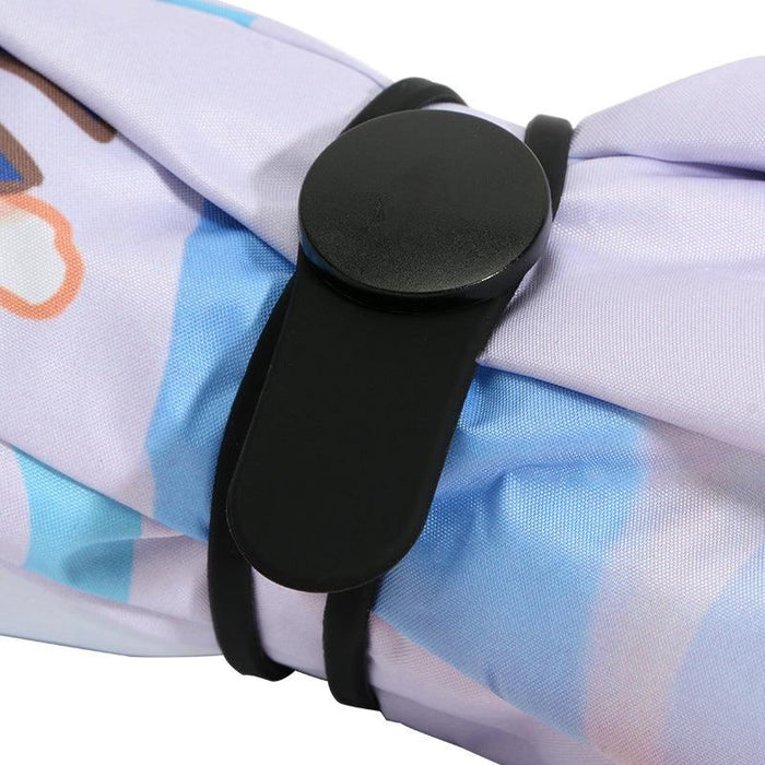 Close-up of custom printed umbrella strap with black buckle on pastel fabric