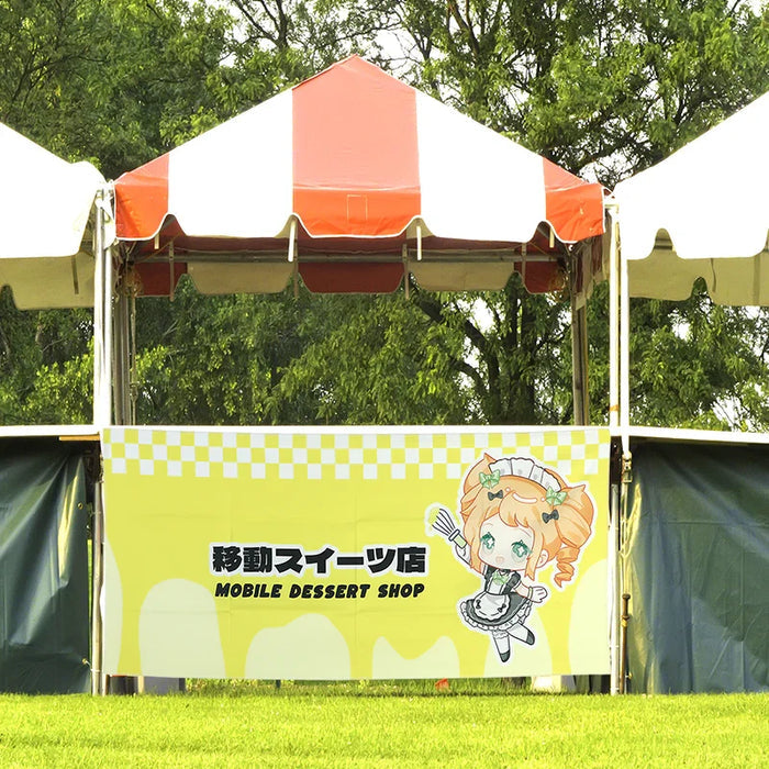 Custom yellow tapestry banner with anime character and text 'Mobile Dessert Shop' at outdoor booth