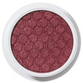 ColourPop Drift Super Shock Shadow displays a metallic cranberry-burgundy shimmer, pressed with a quilted scale pattern, sitting in a round white pot on a plain white studio background.