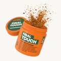 Oranger Behälter mit Text "FINAL TOUCH", Gewürzpulver spritzt heraus.