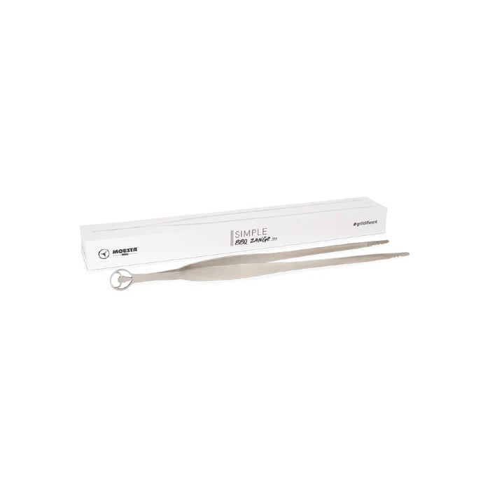 Lange silberne Grillpinzette neben einer weißen Verpackung.