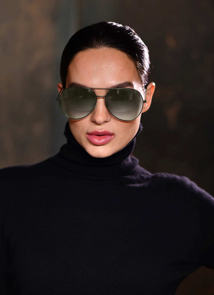 Beautiful girl wearing a pair of olive green aviator sunglasses and black turtle neck pure cashmere sweater