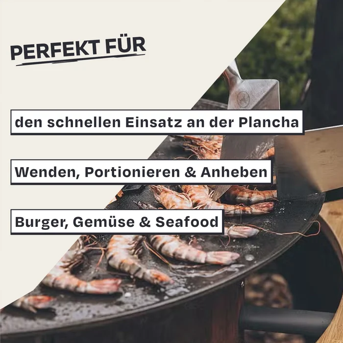 Mehrere Garnelen werden auf einer heißen Plancha mit einem großen Spatel gewendet.